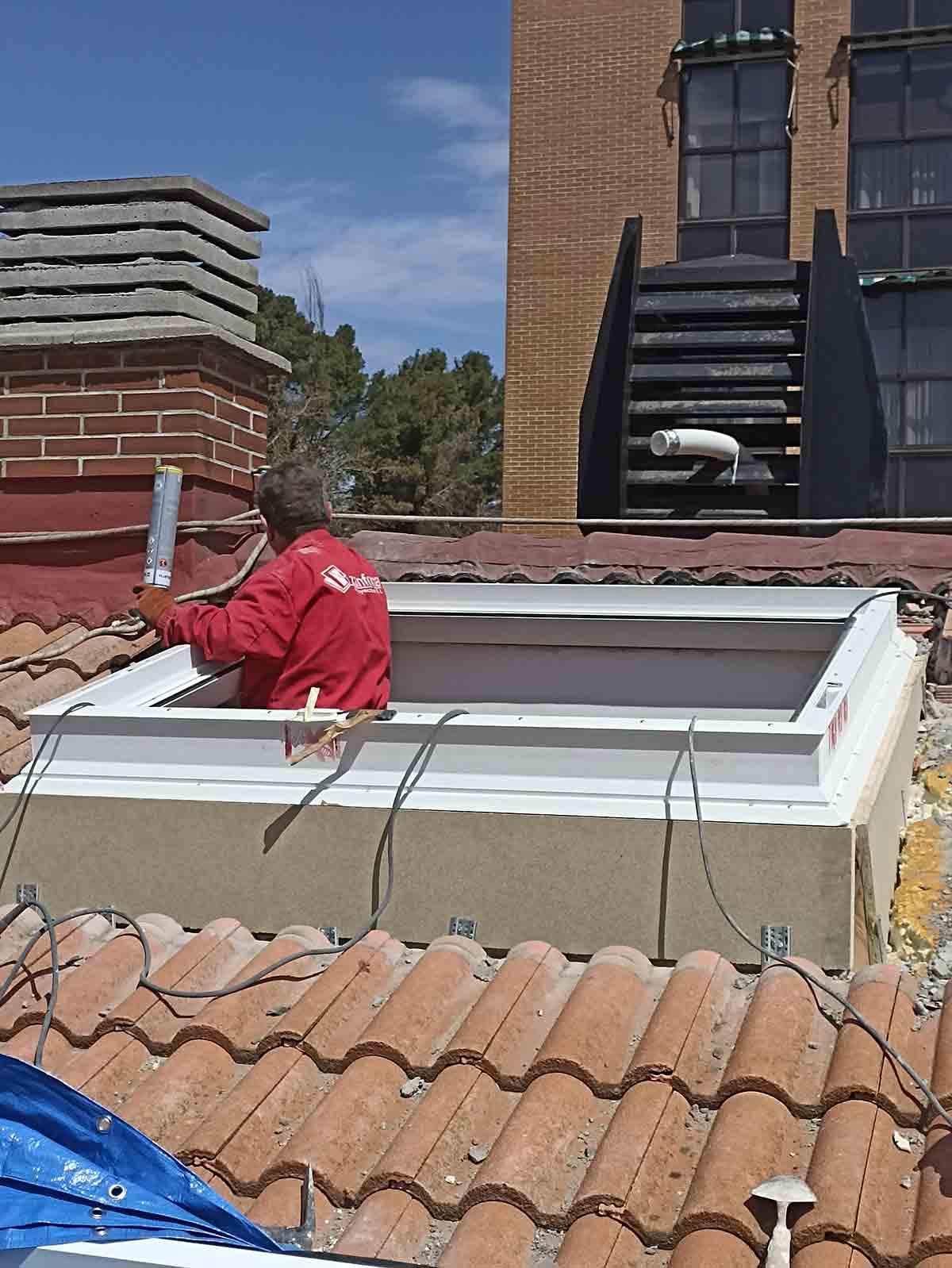 Detalle exterior. Trabajadores en tejado cambiando Claraboya en Mariano de los Cobos, Valladolid.