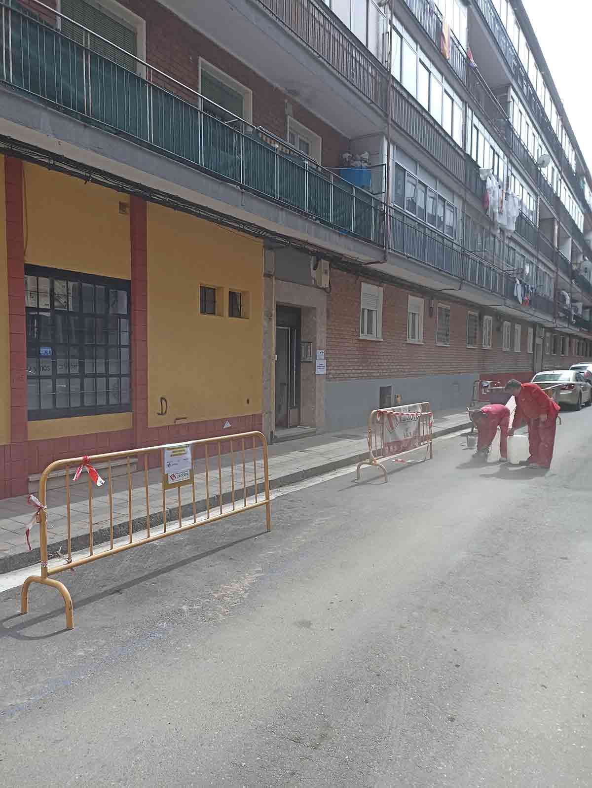 Trabajadores en fachada exterior portal sin reformar en Valladolid.