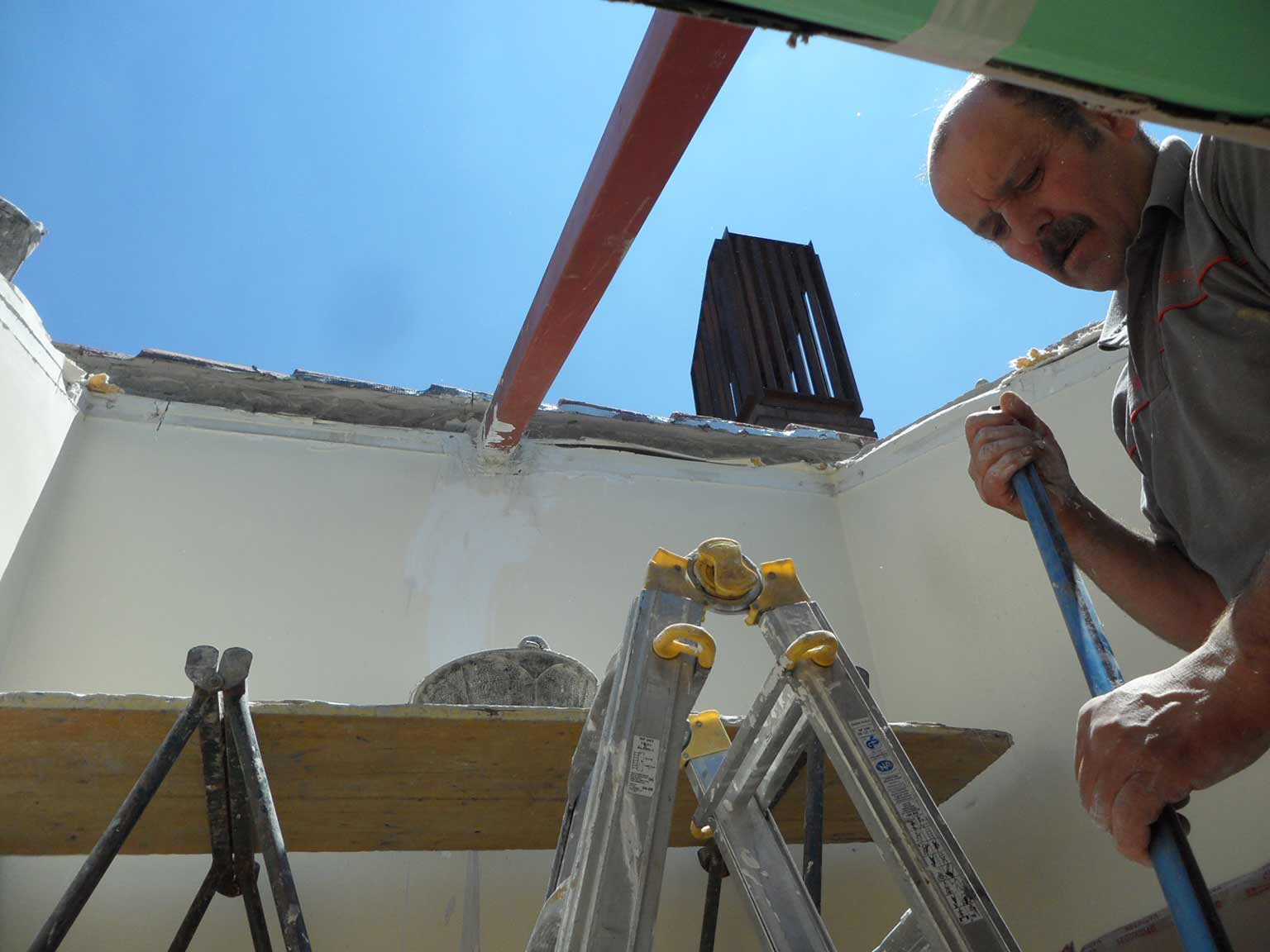 Detalle trabajador instalando dos ventanas Velux en un tejado en Antonio Machado.