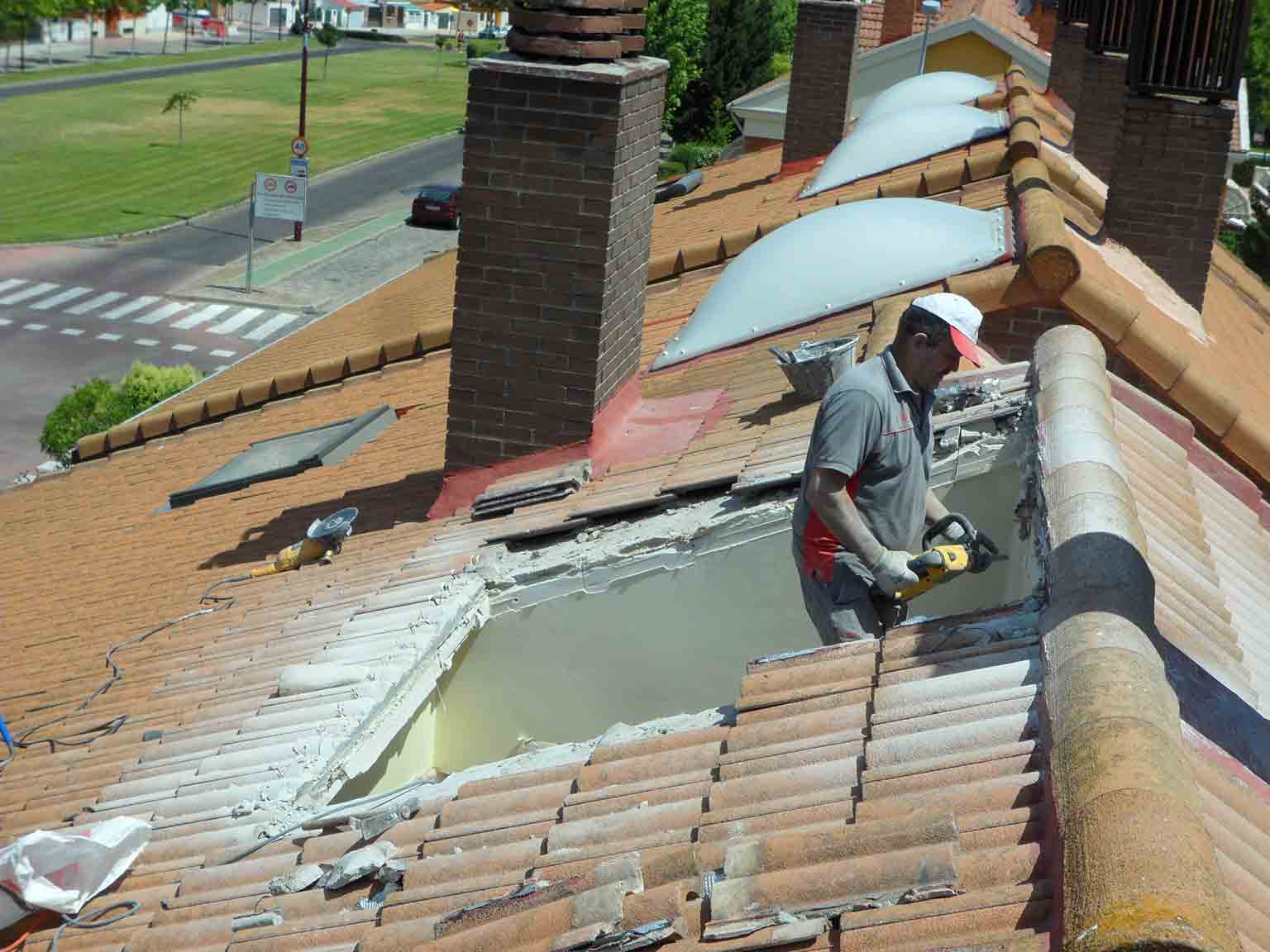 Trabajador reformando tejado con dos ventanas Velux instaladas en Antonio Machado.